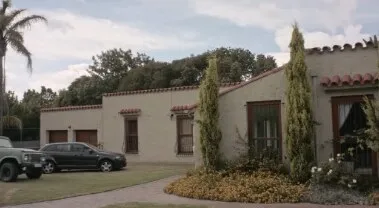 A Spanish-style country house with cars parked in the driveway